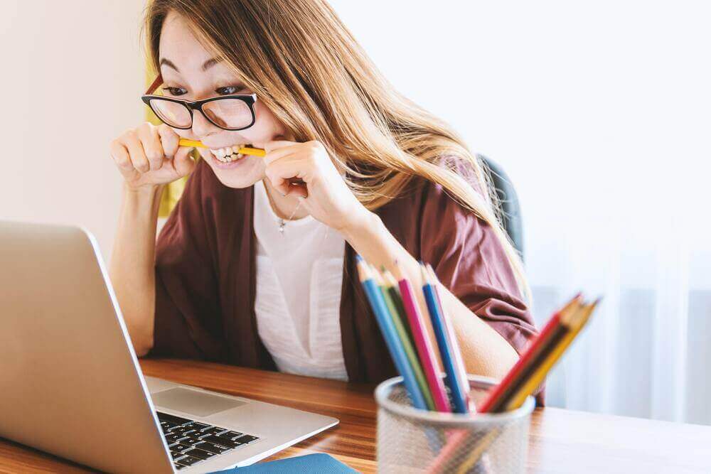 Monitor Social Media for Negative Reviews - woman biting a pen