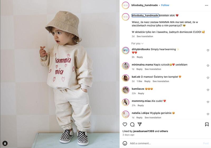 Zrzut ekranu posta na Instagramie opublikowanego przez markę Bliss Baby 2 lutego 2025. Zdjęcie przedstawia dziecko ubrane w kremowy komplet dresowy oraz beżowy kapelusz. Po prawej stronie widać treść posta, w którym marka piszę o składzie kompletu (bawełna i len) oraz entuzjastyczne komentarze opatrzone emotikonami w kształcie serca lub twarzy z sercami zamiast oczu.